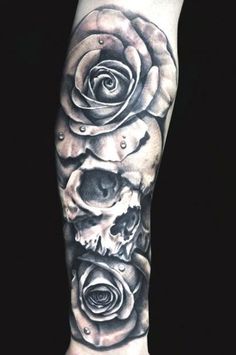 a man's leg with a skull and roses on it