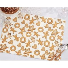 a white table topped with gold foiled cookies and pretzel shaped napkins