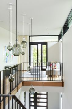 an open floor plan with multiple lights hanging from it's ceiling and glass balconies