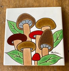 a ceramic tile with three mushrooms on it