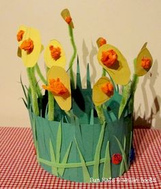 some paper flowers are in a vase on a table