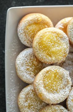 powdered sugar covered pastries in a white dish