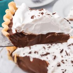 a piece of chocolate pie with whipped cream on top is being held by a fork