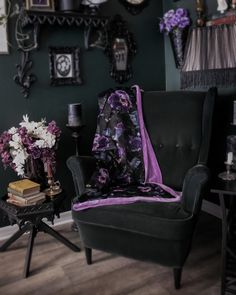 a living room filled with furniture and pictures on the wall next to a table topped with flowers