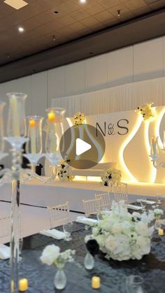 a table with flowers and candles on it in front of a sign that says n & s