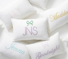 six embroidered pillows with names on them