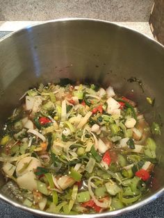 a metal bowl filled with vegetables on top of a counter