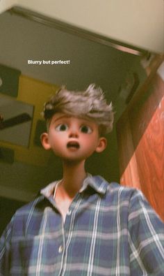 a young boy wearing a plaid shirt and looking up at the ceiling with his mouth open