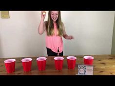 a girl standing in front of red cups