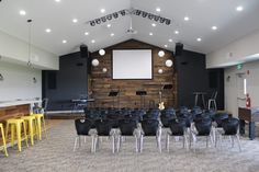 an empty room with chairs and a projector screen