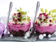 three desserts in glass bowls with silver spoons