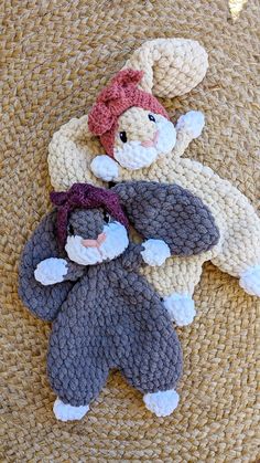 three crocheted stuffed animals laying on top of a woven mat, one is wearing a pink hat