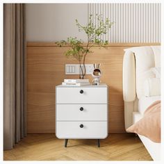 a white dresser sitting next to a bed in a room with wooden floors and walls