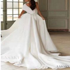 a woman in a white wedding dress posing for the camera with her hands on her hips