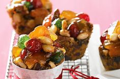 three muffins with fruit and nuts in them sitting on a cooling rack, ready to be eaten