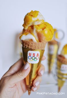 a person holding an olympic ice cream cone