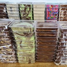 plastic containers filled with different types of desserts on top of a wooden table in a store