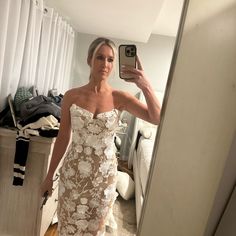 a woman is taking a selfie in her wedding dress while standing in front of a mirror