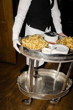 a woman standing in front of a serving tray filled with food