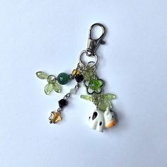 a giraffe keychain with charms attached to it's sides on a white surface