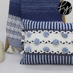 two blue and white pillows sitting next to each other