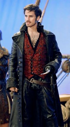 a man dressed in black and red standing next to a pirate