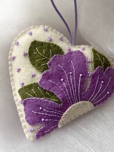 a heart shaped ornament with purple flowers on it