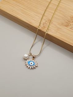 DESCRIPTION: This dainty diamond evil eye charm necklace features a stunning crystal pendant accented with a beautiful pearl bead. A perfect blend of elegance and protection, it makes an ideal gift for her on any occasion! BEST FEATURES: The combination of a diamond evil eye charm and pearl bead creates a unique and stylish piece that stands out. Crafted with premium crystals and genuine pearls, ensuring durability and lasting beauty. Suitable for both casual and formal occasions, making it a ve Elegant Crystal Jewelry, Necklace With Pearl, Customer Gifts, Diamond Evil Eye, Evil Eye Charm, Perfect Gift For Her, Crystal Pendant, Pearl Beads, Crystal Jewelry