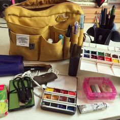 an assortment of crafting supplies on a table next to a bag and other items