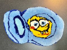 a close up of a spongebob rug on a table with a light blue background