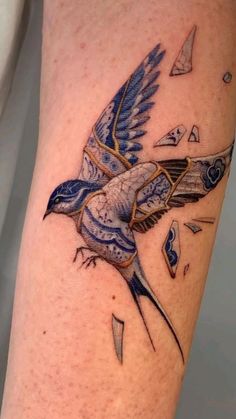 a blue bird flying through the air with its wings spread out and broken in half