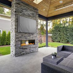 an outdoor living room with a fireplace and couches