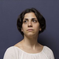 a woman in white shirt looking up at the camera