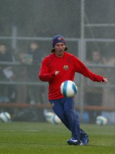 a man kicking a soccer ball on top of a field