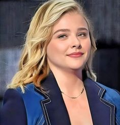 a woman with blonde hair wearing a blue jacket