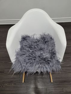 a white chair with grey fur on it