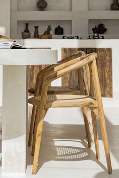 a wooden chair sitting next to a white table