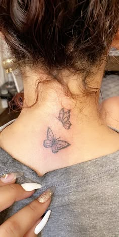 a woman with a butterfly tattoo on her neck