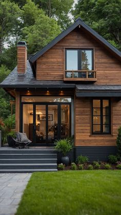 a house that is made out of wood and has black trim on the front door