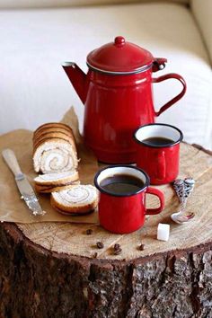 two cups of coffee are next to a red teapot on a tree stump with the words good morning