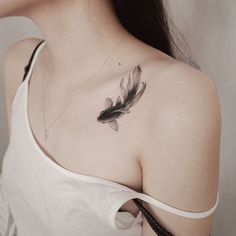 a woman with a feather tattoo on her shoulder