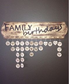 a wooden sign that says family birthdays hanging on the wall with lots of buttons