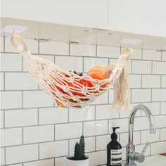 a kitchen sink with a hanging hammock over the faucet