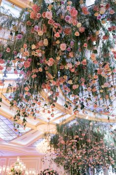 an elaborate chandelier with pink flowers hanging from the ceiling