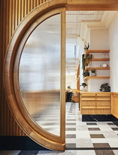 an open wooden door leading into a room with black and white checkered flooring