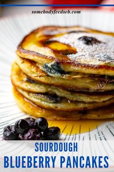 blueberry pancakes with powdered sugar on top and text overlay reads sourdough blueberry pancakes