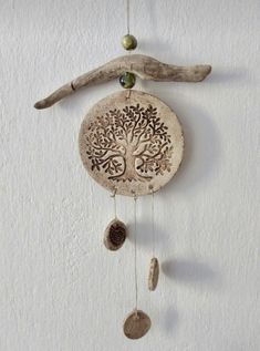 a wooden wall hanging with a tree on it's side and two beads hanging from the top