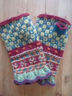 two knitted mittens sitting on top of a wooden table