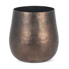 a large metal vase sitting on top of a white surface