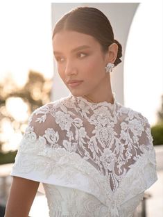 a woman in a white wedding dress is posing for the camera with her hand on her hip